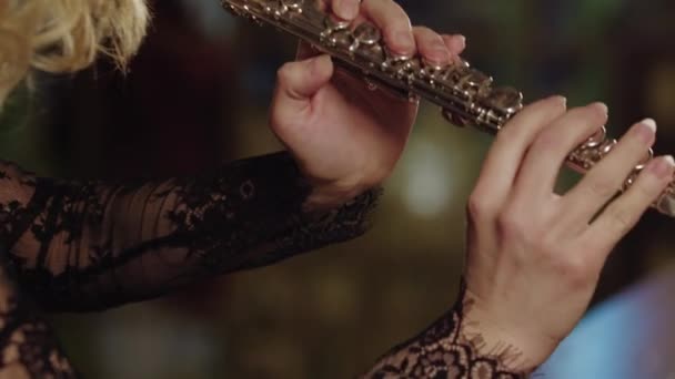 Eine Frau spielt Flöte auf einem Hintergrund aus Glasfenstern - Filmmaterial, Video