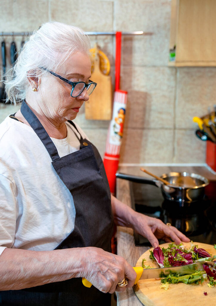 Seniorin kocht in der Küche - Foto, Bild