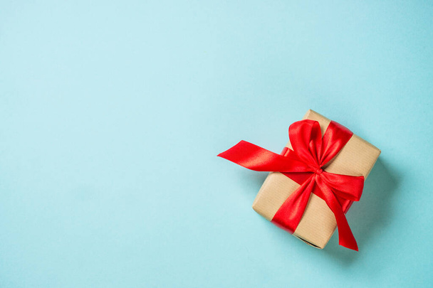Christmas present box with red ribbon at blue. - Foto, Imagem