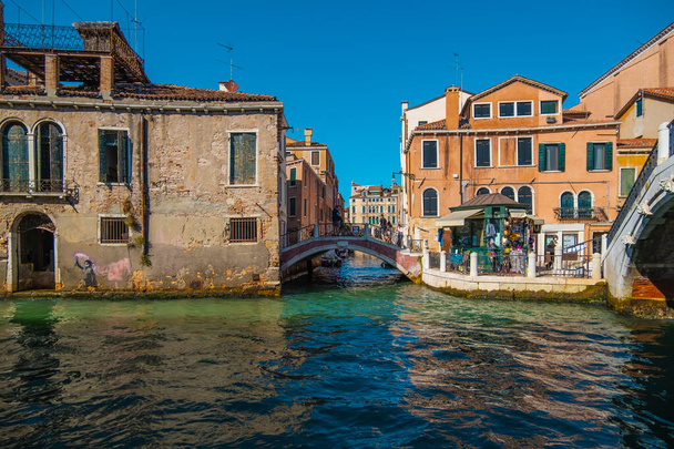 VENICE, ITALY - August 27, 2021:  View of people crossing the bridge over the beautiful canals of Venice. - 写真・画像