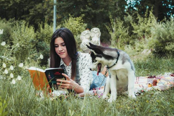 Joven hermosa chica jugando con su lindo perro husky mascota  - Foto, Imagen