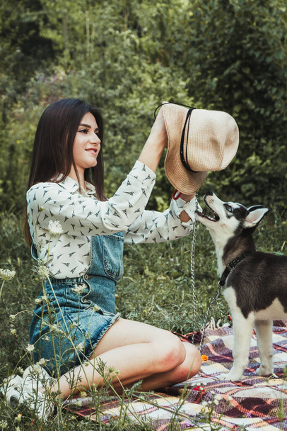 Young beautiful girl playing with her cute husky dog pet  - Photo, Image