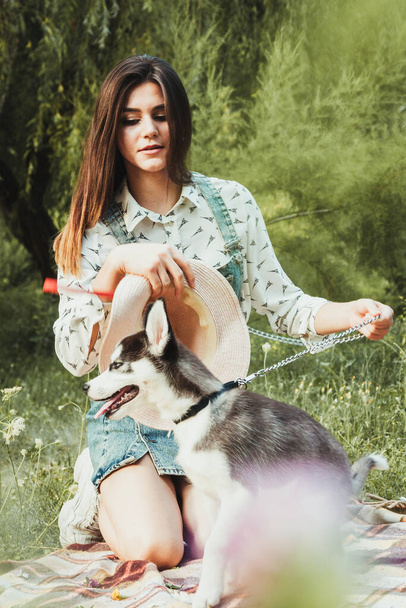 Young beautiful girl playing with her cute husky dog pet  - Foto, afbeelding