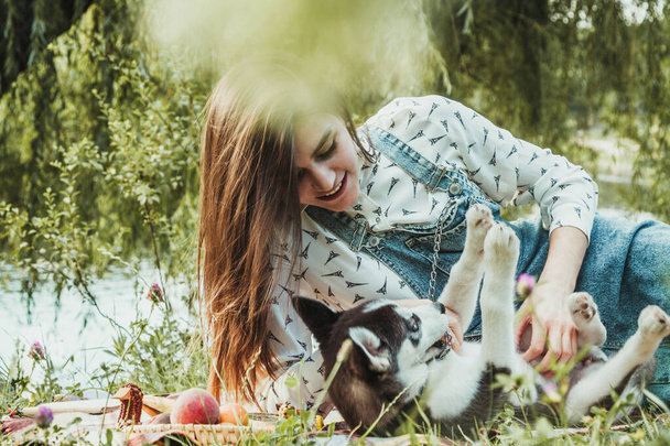 Νεαρό όμορφο κορίτσι παίζει με χαριτωμένο husky κατοικίδιο ζώο σκυλί της  - Φωτογραφία, εικόνα