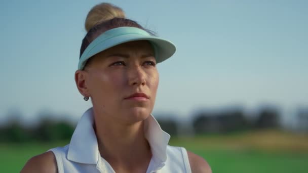 Komoly golfozó arccal nézi a zöld mezőt. Koncentrált nő állni golfpálya - Felvétel, videó