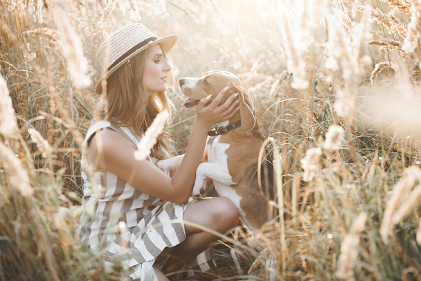 Attractiive young woman outdoors with her pet. Owner and dog together. Friends forever. Lady and beagle - Φωτογραφία, εικόνα