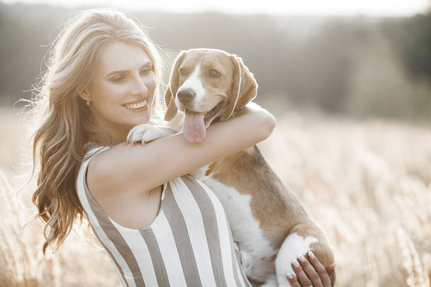 Attractiive young woman outdoors with her pet. Owner and dog together. Friends forever. Lady and beagle - Foto, immagini