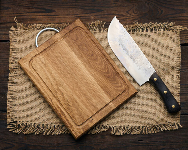 Large kitchen knife on an empty wooden cutting board, top view - Foto, Imagem
