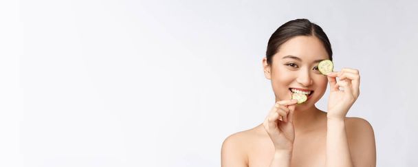 Natural casero fresco pepino facial almohadillas para los ojos máscaras faciales. Mujer asiática sosteniendo almohadillas de pepino y sonrisa relajarse con natural casero
 - Foto, imagen