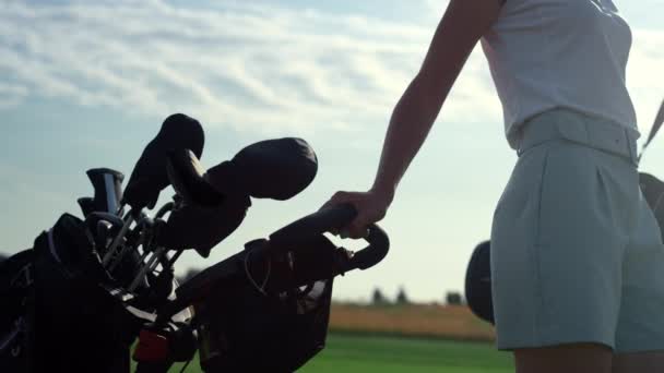 Golf personne prenant des clubs sac trolley dans le country club. Parcours de golf de randonnée femme. - Séquence, vidéo