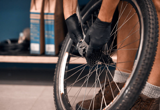 Ramenez vos roues sur la route. Plan recadré d'un homme réparant un vélo dans un atelier. - Photo, image