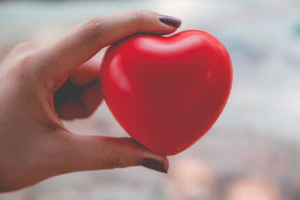 Женщина держит красное сердце использовать для фона - Фото, изображение