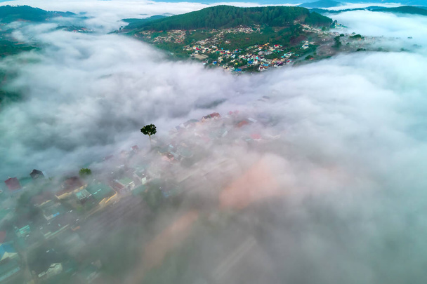 Вид с воздуха на город в утреннем тумане прекрасен в горах Да Лат, Вьетнам - Фото, изображение
