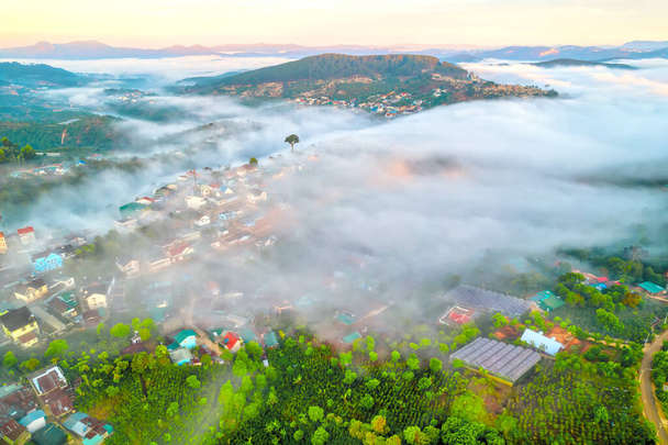Вид с воздуха на город в утреннем тумане прекрасен в горах Да Лат, Вьетнам - Фото, изображение
