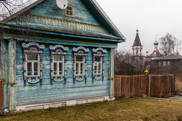 Oud Russisch huis met tegels op de achtergrond van de tempel in  - Foto, afbeelding