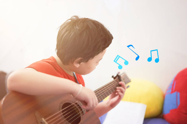 bambino ragazzo suonare la chitarra con nota grafica - Foto, immagini