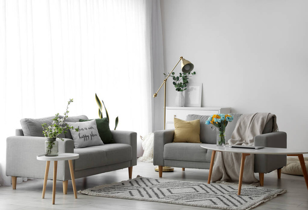 Interior elegante da sala de estar com sofás confortáveis e decoração floral - Foto, Imagem