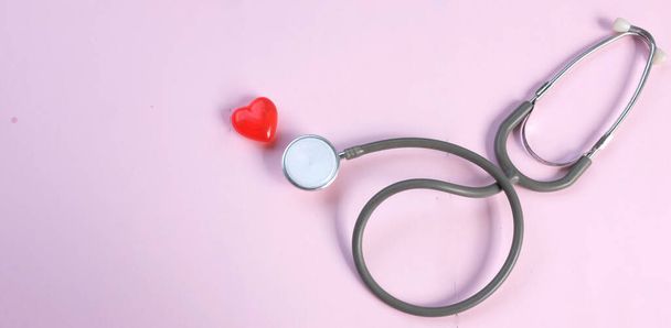 top view a Stethoscope and red hearts on a pink background. Health care concept. - Foto, immagini