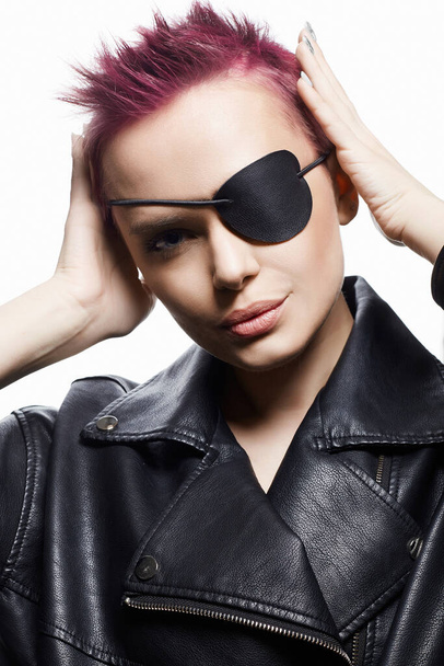 beautiful woman with pirate eye patch and short pink hair. portrait of beauty young woman in leather. Trendy coloring Hairstyle - Fotó, kép