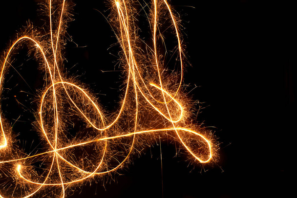 Sparkle firework writing sign/symbol on black background - Фото, изображение