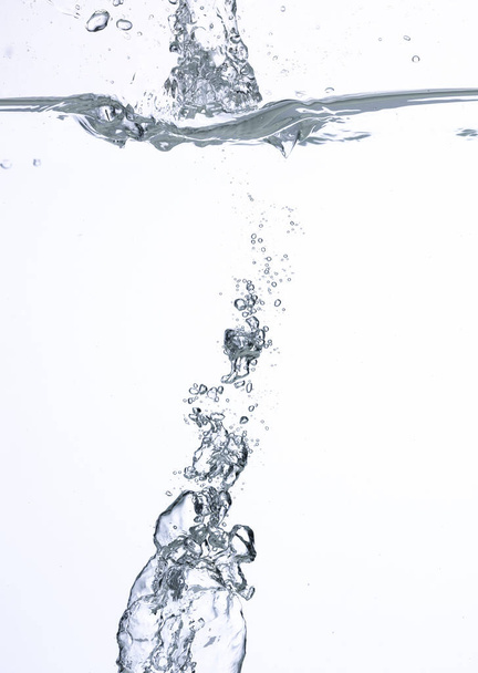 Een abstracte achtergrond gecreëerd door luchtbellen in water onder witte verlichting. - Foto, afbeelding