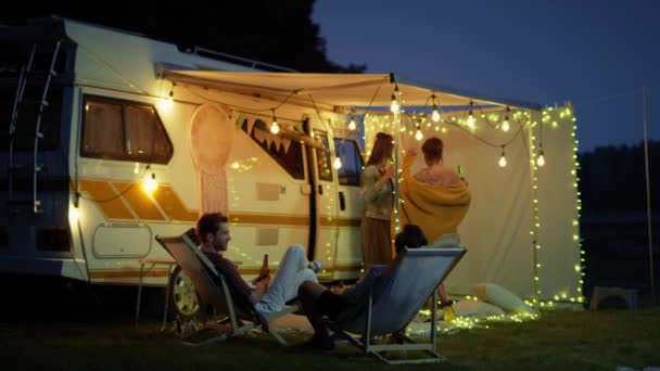 Grupo de jóvenes amigos que pasan el tiempo en el camping y beber cerveza por la noche. Fotografía con cámara de helio RED en 8K   - Metraje, vídeo