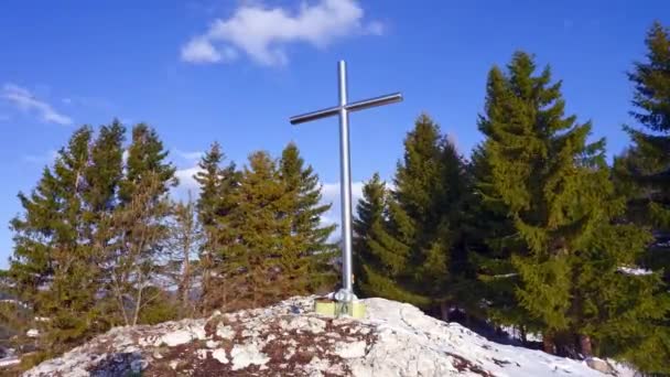 Christian iron cross on a rock. Blue sky with small clouds.Trees in the background. Timelapse FHD - Footage, Video