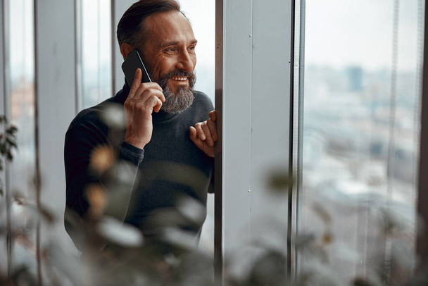 Boldog felnőtt férfi telefonál, miközben beszél - Fotó, kép