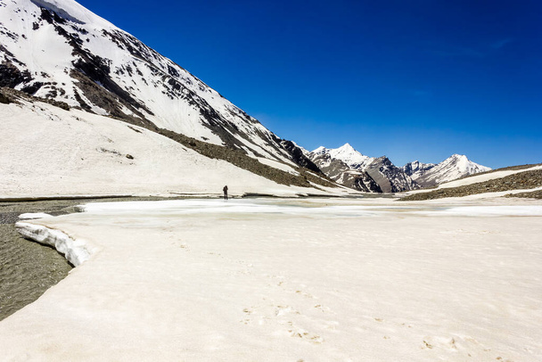 Zanskar, India - July 2012: A trekking trail through thick snow leading to the high altitude pass of Shingo La in the Himalayan wilderness of Zanskar. - Photo, image