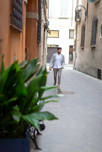 beautiful elegant Italian dark-haired boy strolls through the historic center. High quality photo - Valokuva, kuva