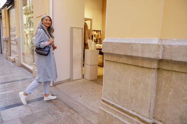 Umtriebige ältere Frau spaziert durch die Stadt - Foto, Bild