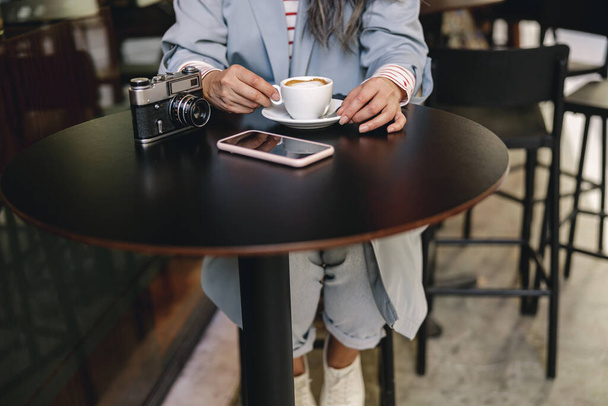 Modern lady sitting with coffee at coffee shop - Fotoğraf, Görsel