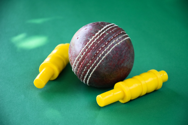 Старый и используемый мяч для крикета на темном фоне, используемый для тренировки по крикету, мягкий фокус. - Фото, изображение