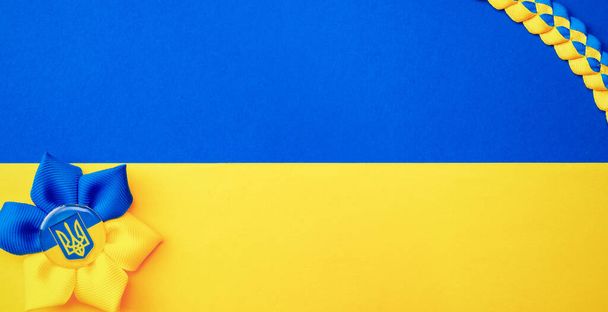 Símbolo de tridente de flores ucraniano isolado na bandeira azul amarela. Amarelo e azul banner fundo, flat lay, espaço de cópia - Foto, Imagem