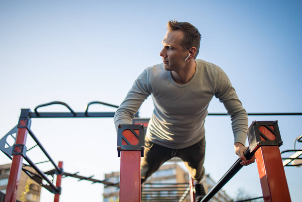 A man is engaged in sports outside on the playground, fitness, sport, lifestyle. - Photo, Image