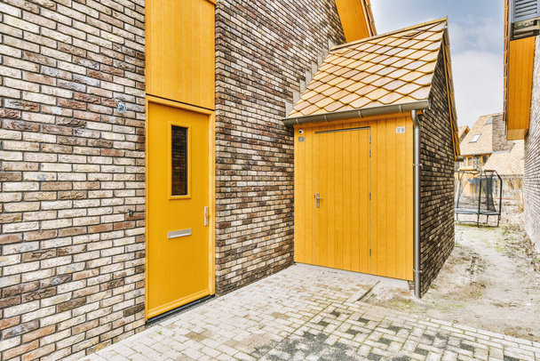Είσοδος σε κατοικίες κατασκευασμένες από τούβλα με ξύλινα ένθετα - Φωτογραφία, εικόνα