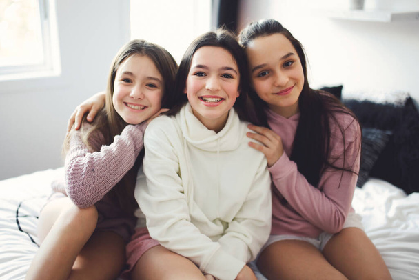 Three excited teenager girls having fun together, enjoying laze leisure time at home - Fotoğraf, Görsel