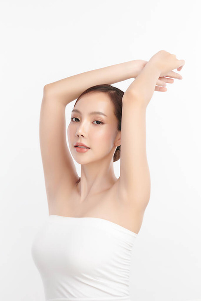 きれいな衛生的な脇の下や白い背景に腕を披露する手を持ち上げる美しい若いアジアの女性,滑らかな脇の下の清潔さと保護の概念. - 写真・画像