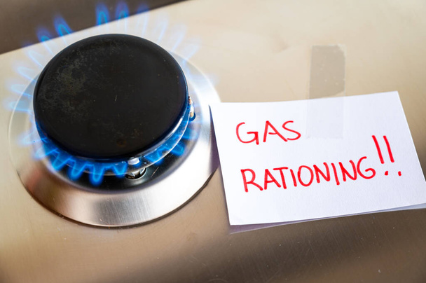 Gas stove, with blank note next to it with the text "gas rationing". Rationing and insufficiency in gas flows. Energy crisis. - Zdjęcie, obraz