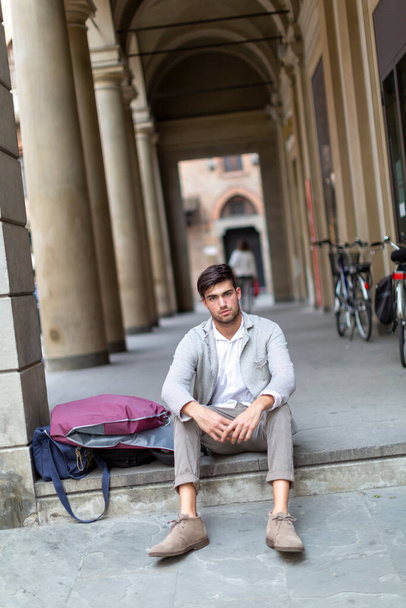 handsome Italian dark-haired boy desperate broken dreams sitting with elegant clothes. High quality photo - Foto, imagen