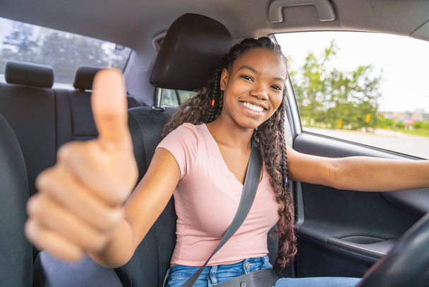 Young black teenage driver seated in her new car - Foto, Bild