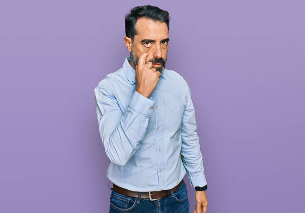 Middle aged man with beard wearing business shirt pointing to the eye watching you gesture, suspicious expression  - Photo, Image