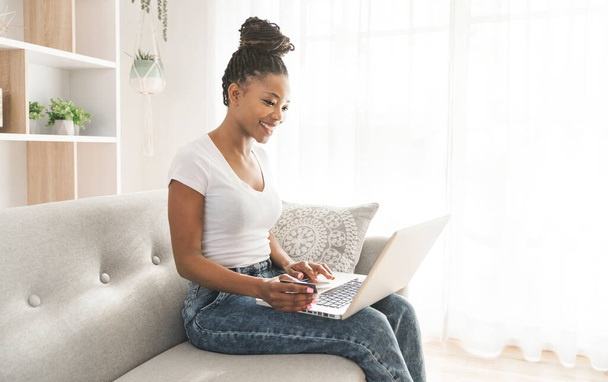 Portrait of A African Woman sit on the sofa at home using laptop - Foto, immagini