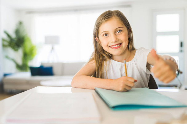 Pretty little girl enjoys learning and doing some homework - Photo, Image