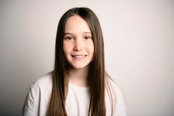 Young brunette pre teen girl on studio white - Foto, imagen