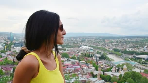 "Panning view young caucasian woman stand on viewpoint enjoy scenic Tbilisi city panorama from Narikala fortress in summer. Travel in Georgia - Felvétel, videó