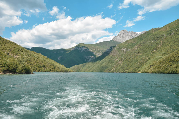 アルバニアのダイナミックアルプスのコマーニ湖のボート旅行で山や緑の森と美しい風景 - 写真・画像