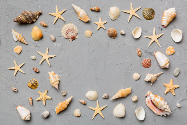 Concepto de hora de verano Composición plana con hermosas estrellas de mar y conchas de mar en la mesa de colores, vista superior con espacio de copia para el texto. - Foto, Imagen