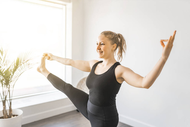Sporty young woman doing yoga practice and having natural balance - Fotó, kép