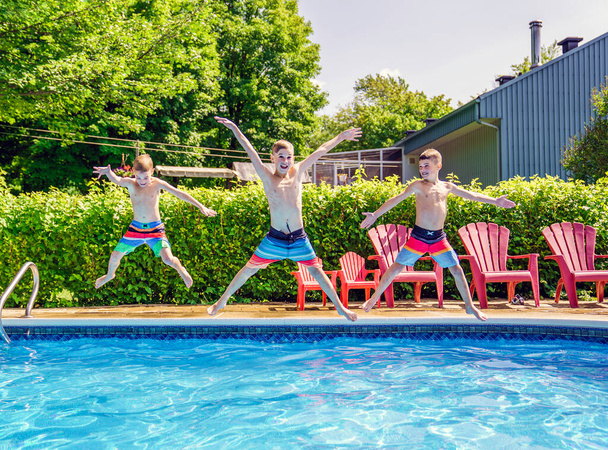 Childrens playing in pool on summer time jumping - Foto, Imagen